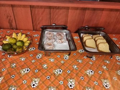 KriにあるWarahnus dive homestayのパンと果物のトレイ2つが付いたテーブル