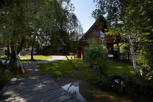 una casa con un passaggio in legno di fronte a un cortile di Siedlisko Zatoka a Augustów