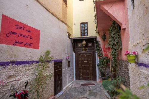 an alley with a door with a sign on it at Riad bel kayed in Fès