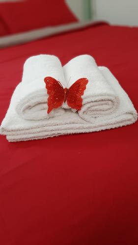 een witte handdoek met twee vlinders op een bed bij Casa Ninnì Sanremo in Sanremo