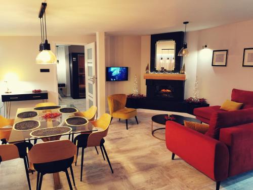 a living room with a table and a red couch at Apartament 34 in Ciechanów