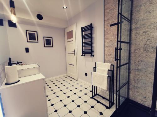 a white bathroom with a sink and a toilet at Apartament 34 in Ciechanów