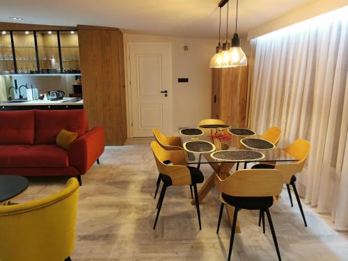 a living room with a table and yellow chairs at Apartament 34 in Ciechanów