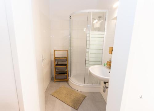 a white bathroom with a shower and a sink at Central Apartments Vienna in Vienna