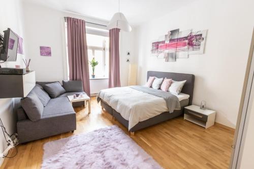 a bedroom with a bed and a couch at Central Apartments Vienna in Vienna