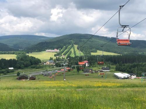 a group of people riding a ski lift in a field at Apartmán Ramzová Kometa in Ostružná