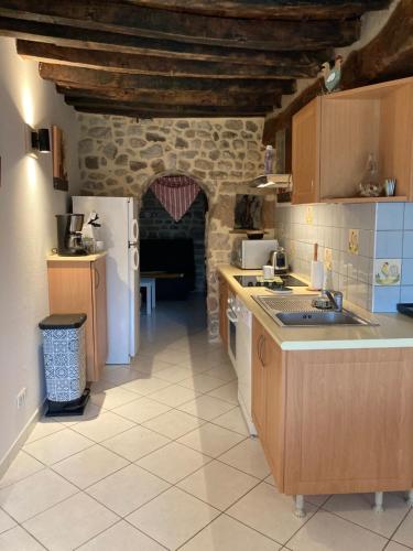 eine Küche mit einem Kühlschrank und einer Arbeitsplatte in der Unterkunft L'Atelier de la Forge La forge in Martigny-le-Comte