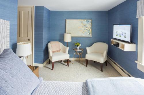 um quarto com paredes azuis e 2 cadeiras e uma televisão em 33 Main em Lenox