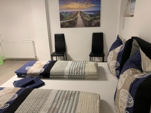 a room with two beds and two chairs at Ferienwohnung Bella in Hühnerfeld