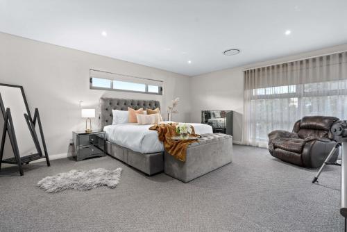 a bedroom with a large bed and a chair at Family Vacation Escapade Shops Beach and Sun Await in Perth