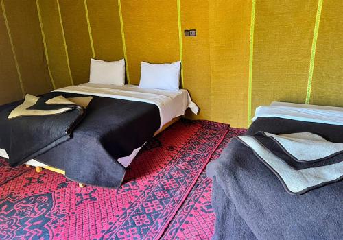 a room with two beds in a green wall at Merzouga best camp in Merzouga