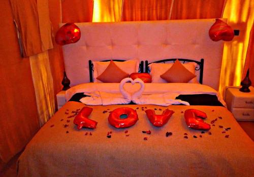 a bedroom with a bed with red decorations on it at Merzouga best camp in Merzouga