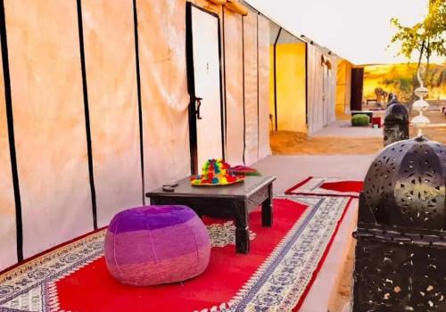 a room with a table and a red carpet at Merzouga best camp in Merzouga