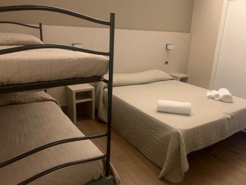 a bedroom with two bunk beds with towels on it at Hotel Royal Plaza in Rimini