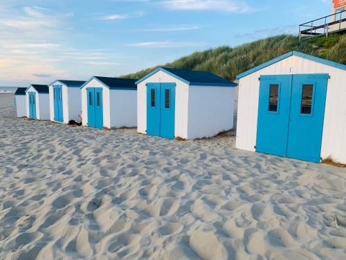 a row of beach huts on a sandy beach at Balsemientexel in De Koog