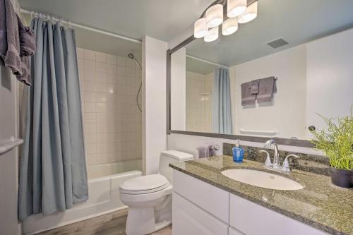 a bathroom with a sink and a toilet and a mirror at Downtown Kona Condo with Pool Access Walk to Beach! in Kailua-Kona