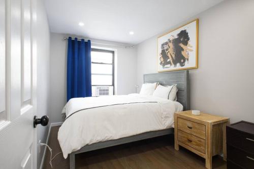 350-2A Prime gramercy Newly renovated 1BR sleeps 4 في نيويورك: غرفة نوم بسرير وستارة زرقاء