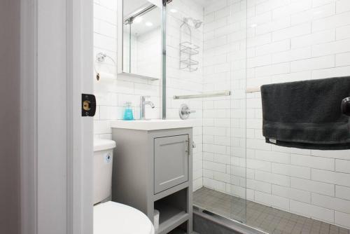 a white bathroom with a toilet and a sink at 350-2A Prime gramercy Newly renovated 1BR sleeps 4 in New York