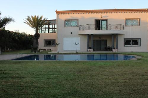 une maison avec une piscine en face de celle-ci dans l'établissement Jnane Ville Verte, à Casablanca