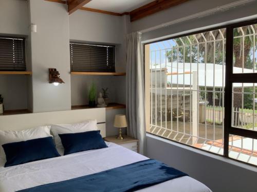 a bedroom with a bed and a large window at Impala Suite -Entire Unit- 2 bedroom with 1 ensuite bathroom in Ladysmith