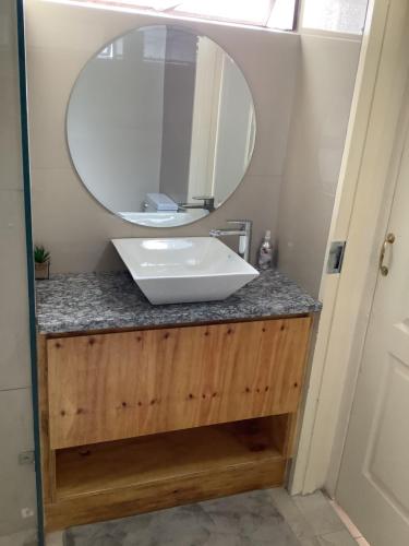 een badkamer met een wastafel en een spiegel op een aanrecht bij Impala Suite -Entire Unit- 2 bedroom with 1 ensuite bathroom in Ladysmith