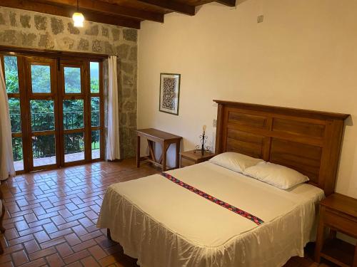 a bedroom with a bed and a large window at Hotel Posada La Vereda in Cuetzalán del Progreso
