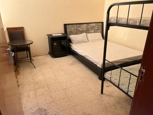 a bedroom with two bunk beds and a table at Gulf building, homestay in Sharjah