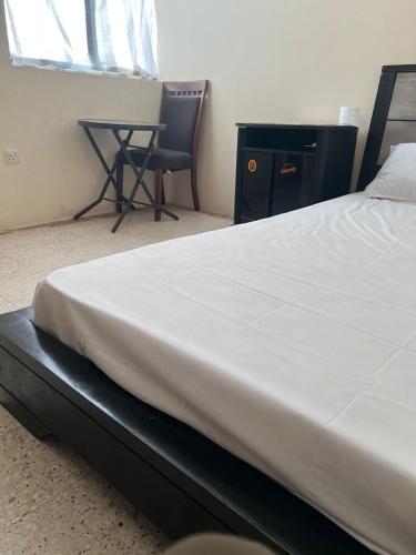 a bed in a room with a desk and a chair at Gulf building, homestay in Sharjah