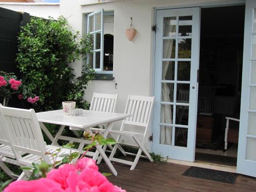 a white table and chairs on a patio at Rose and Ale Self Catering Units in Gonubie