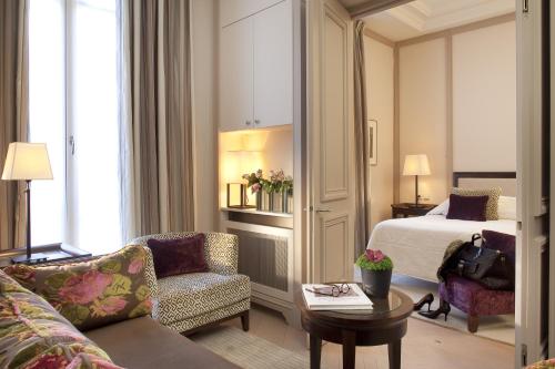 ein Hotelzimmer mit einem Bett, einem Sofa und einem Tisch in der Unterkunft Hôtel De l'Arcade in Paris