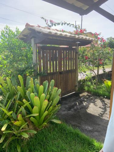 un giardino con un cancello di legno e un cespuglio di Casa dos Paulistas - Ilha de Boipeba a Ilha de Boipeba