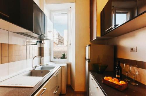 a kitchen with a sink and a bowl of oranges on the counter at Amazing View Vatican in Rome