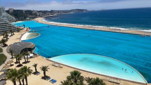 an overhead view of a large swimming pool next to a beach at San Alfonso Mágico in Algarrobo