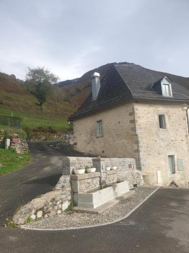 uma casa de pedra com uma parede de pedra ao lado de uma estrada em Château d'Arance em Cette-Eygun