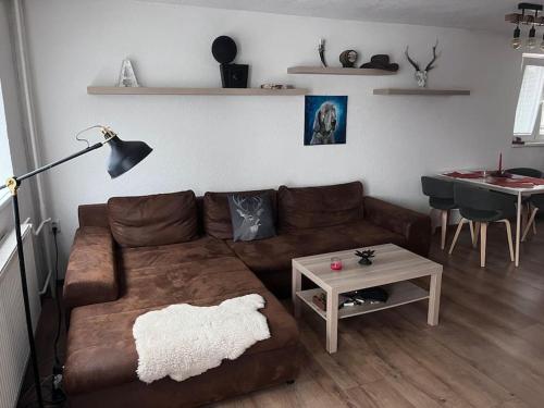 uma sala de estar com um sofá castanho e uma mesa em Chata s panoramatickou saunou em Chyše