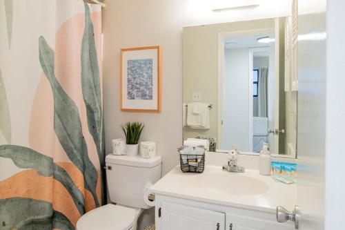 a bathroom with a toilet and a sink and a mirror at Beachfront Stylish Condo - Stunning Views! in Gulf Shores