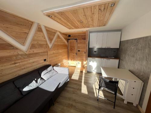 ein Zimmer mit einem Sofa und einem Tisch sowie einer Küche in der Unterkunft FRONT DE NEIGE MONTGENEVRE in Montgenèvre