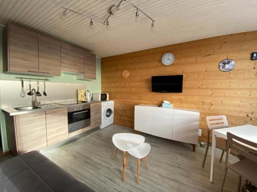 une cuisine avec un canapé, une table et un réveil dans l'établissement Appartement 5 Personnes au pied des pistes - WIFI -, à Chamrousse