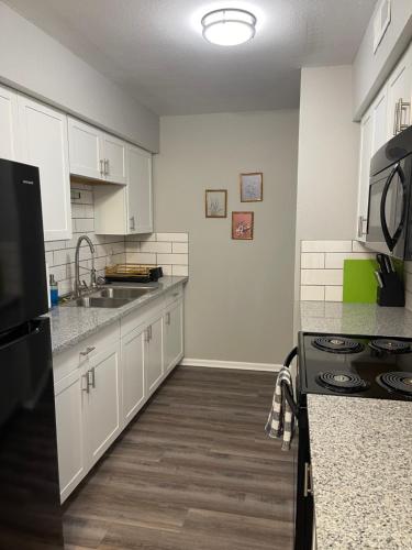 a kitchen with white cabinets and a sink at The Deannie Apt #6 - Simple and Homey 2bd w/ WiFi in Hamilton