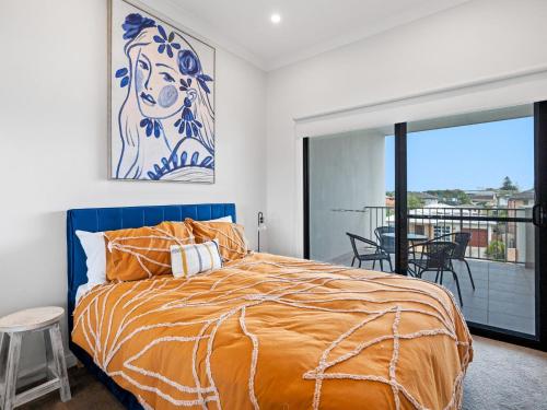 a bedroom with a large bed and a balcony at North Entrance Holiday Home in The Entrance