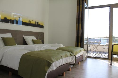 a bedroom with a large bed and a balcony at Mondo hôtel in Tubize