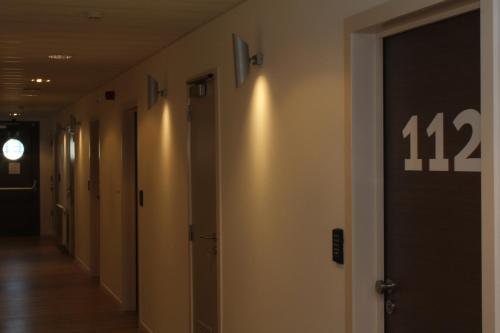 a hallway with a sign on the wall at Mondo hôtel in Tubize