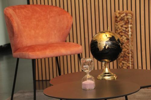 a table with a globe and a chair and a glass at Mondo hôtel in Tubize