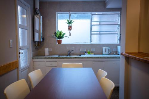 cocina con mesa, fregadero y ventana en Samay Departamentos en Salta