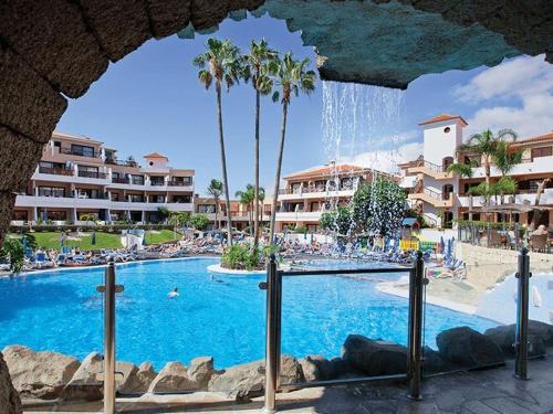 een zwembad in een resort met palmbomen bij Sweet home ocean golf resort in San Miguel de Abona