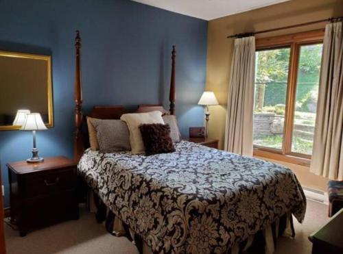 a bedroom with a bed and a window at Chalet-Style Condo - 5 minutes to Lifts and village! in Mont-Tremblant