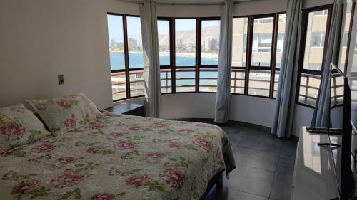 a bedroom with a bed and a view of a pool at DEPTO SUITE II in Iquique