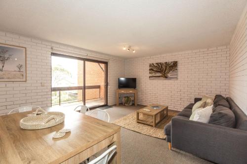 a living room with a couch and a table at Sunrise 15 in Jindabyne