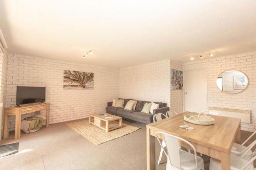 a living room with a couch and a table at Sunrise 15 in Jindabyne