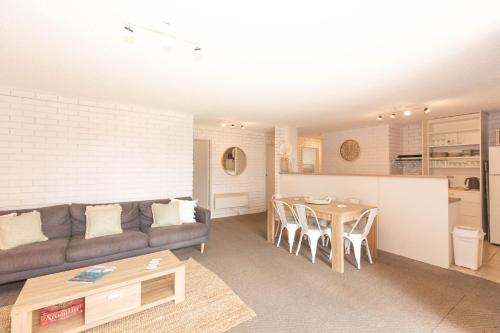 a living room with a couch and a table at Sunrise 15 in Jindabyne